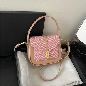 Detail of elegant pink leather bag with red plaid weave and vintage gold clasp in gift box