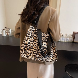 Quilted leopard print tote bag featuring a spacious design and wide black shoulder strap