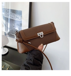 Detail of silver U-shaped metal lock and brown textured leather on a crossbody bag