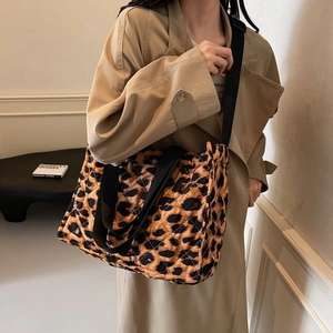 Close-up of leopard print quilted tote bag worn with an adjustable black strap