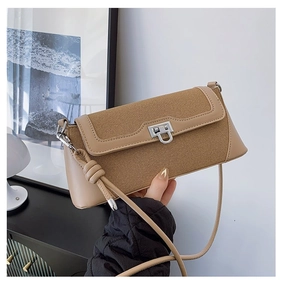 Detailed close-up of khaki canvas and leather shoulder bag with silver metal square lock