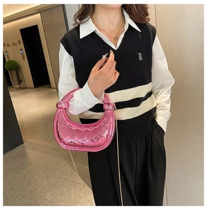 Mannequin portant un sac croissant rose métallisé matelassé avec une chaîne fine