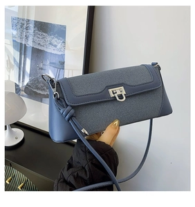 Detail shot of navy blue crossbody bag featuring silver buckle and textured mesh stitching