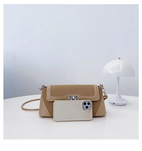 Detail view of khaki canvas crossbody bag with leather trim and phone for size reference