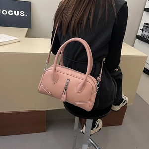 Pink lychee texture shoulder bag with decorative tassels and dual top handles
