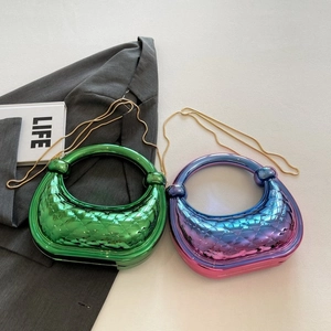 Détail de sacs de soirée métallisés matelassés en vert et violet avec anses rondes