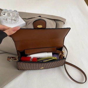Interior view of brown woven shoulder bag showing capacity for lipstick and sunglasses