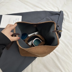Internal view of large capacity matte suede tote bag with magnetic closure and inner items