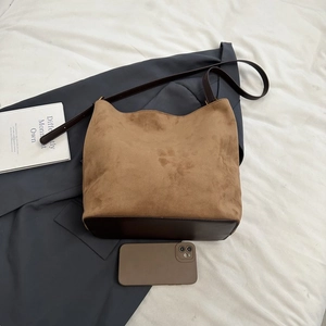 Flat lay of large matte suede tote bag with leather straps and size reference phone