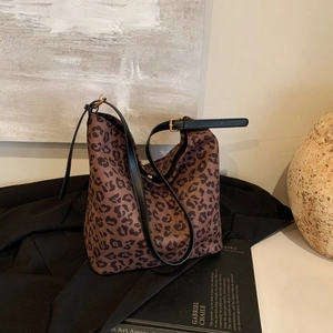 Close-up of leopard print hobo bag with adjustable black leather strap and gold buckle