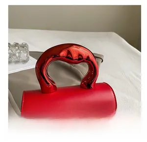 Detailed close-up of a modern red leather bag featuring a unique red metallic handle