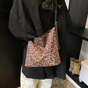 Detail of leopard print tote bag with adjustable black shoulder strap and gold buckle