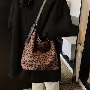Close-up of leopard print hobo bag texture with a black leather shoulder strap