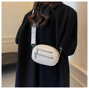 Detail of off-white lychee grain oval crossbody bag with wavy pattern wide strap