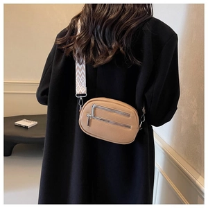 Detail of camel crossbody bag with twin zippers and geometric patterned wide strap