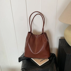 Detailed view of dark brown PU leather tote with stylish glossy finish and long straps