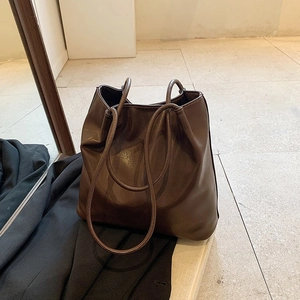 Top-down macro view showing soft texture and glossy finish of the brown leather tote bag