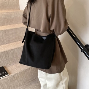 Macro shot of large black matte hobo bag with wide strap and minimalist buckle detail