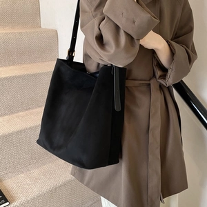 Detail of minimalist black frosted suede tote bag with adjustable leather shoulder strap