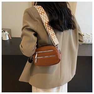 Detail of vintage brown pebbled leather crossbody bag with geometric woven wide strap