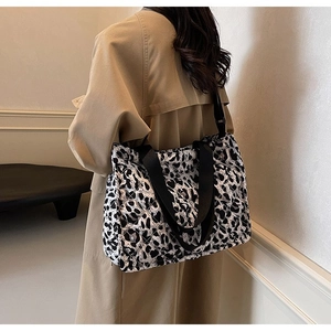 Quilted leopard print tote bag with shoulder strap worn by model in a casual style