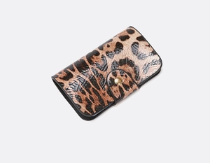 Close-up of leopard print leather wallet with glossy finish and gold metal snap button