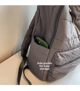 Detailed side view of quilted nylon backpack featuring a functional pocket for smartphone