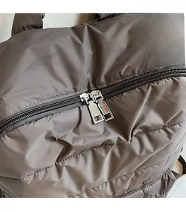 Detail of dual silver metal zippers on quilted nylon fabric with smooth finish