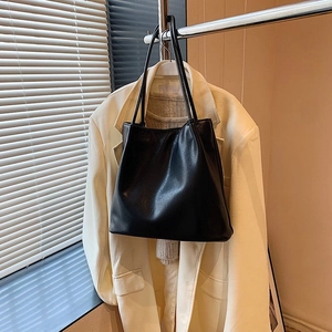 Detail of a minimalist black PU leather shoulder tote bag with elegant slender straps