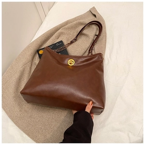 Detail of dark brown vintage PU leather tote bag with gold twist lock and chain strap