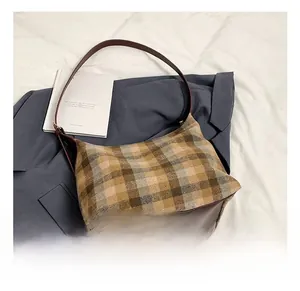 Détail du sac hobo à carreaux avec bordure en cuir marron et texture rétro quadrillée