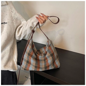 Gros plan d'un sac hobo rétro en laine à carreaux bleu et marron avec bandoulière