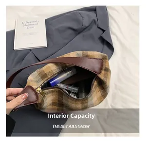 Vue intérieure d'un sac à bandoulière à carreaux montrant sa capacité pour les cosmétiques