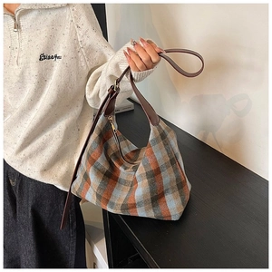 Détail du sac hobo en tweed à carreaux rétro marron avec bandoulière en cuir