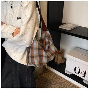 Détail d'un grand sac cabas à carreaux bleu et orange avec bandoulière en cuir