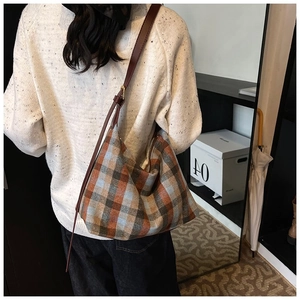 Détail d'un grand sac cabas à carreaux vintage avec bandoulière en cuir réglable