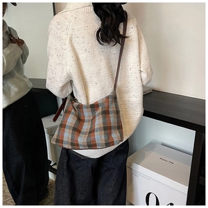 Détail d'un sac à bandoulière à carreaux classiques avec sangle en cuir marron foncé