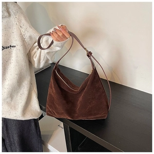 Détail d'un sac hobo en daim marron foncé avec bandoulière et fermeture éclair