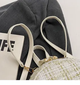 Dettaglio della borsa in tweed bianco con fili dorati e ganci metallici di alta qualità