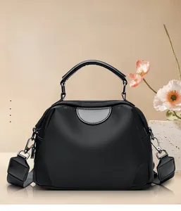 Close-up of black nylon shoulder bag with stitching details and adjustable strap