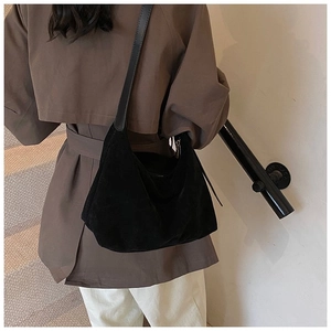 Vue détaillée du sac hobo en daim noir avec bandoulière en cuir et fermeture éclair