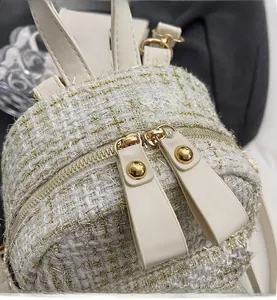 Dettaglio macro delle cerniere dorate lisce su una borsa a tracolla in tweed bianco