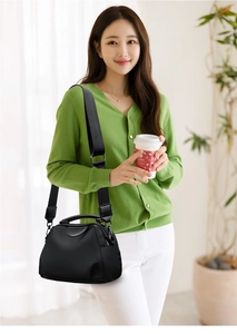 Detail of black nylon shoulder bag with top handle and adjustable wide fabric strap