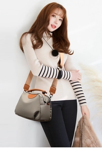 Detail of grey-green nylon handbag with contrast leather handles and wide fabric strap