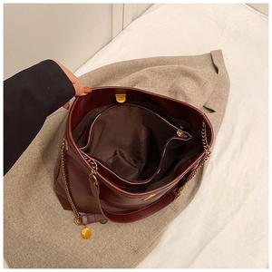 Minimalist burgundy winter tote bag with golden chain handle and large interior pocket