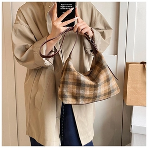Gros plan du sac hobo vintage à carreaux marron avec texture en tweed et bandoulière en cuir