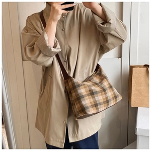 Détail du sac bandoulière vintage à damier aux tons terreux avec bandoulière marron