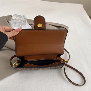 Brown stitch lock underarm bag with woven texture and gold hardware detailing