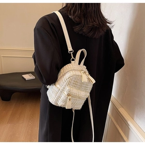 Dettaglio della borsa in tweed beige con filo dorato e cerniera metallica lucida
