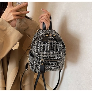 Dettaglio mini zaino in tweed con cerniere dorate e finiture in pelle nera
